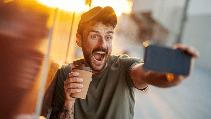 a happy man taking selfie with his coffee