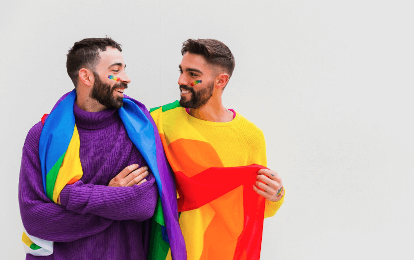 Homosexual couple with LGBT flags on shoulders 