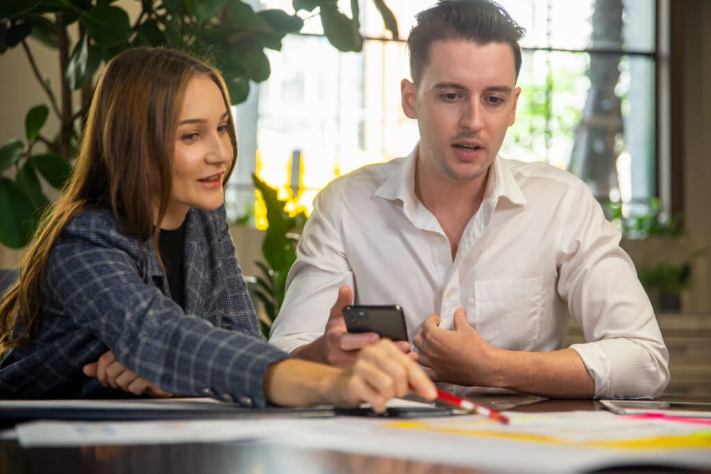 Close-up image of two attractive young people having a business meeting in a modern cafe.