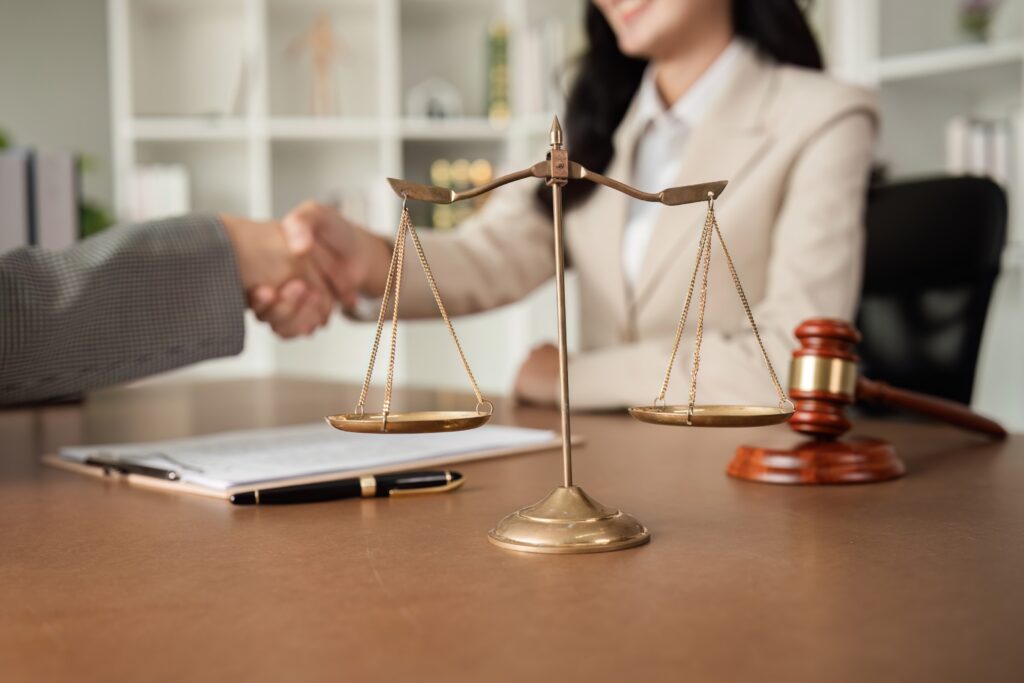 A lawyer and a businesswoman shake hands and reach an agreement on a cooperation contract document, false report, legal action, accused, police, crime, assault, story, protect, circumstances, process, assault, protect, lawyer, police, accuset, assault, lawyer, accuser, protect