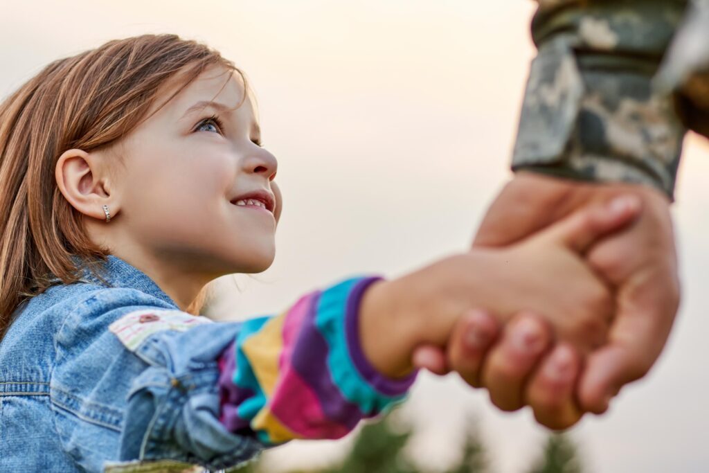 Close up portrait little girl looks at his military father.