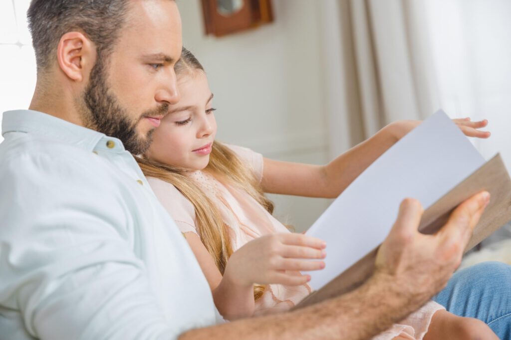 Portrait of pensive father and daughter reading book together