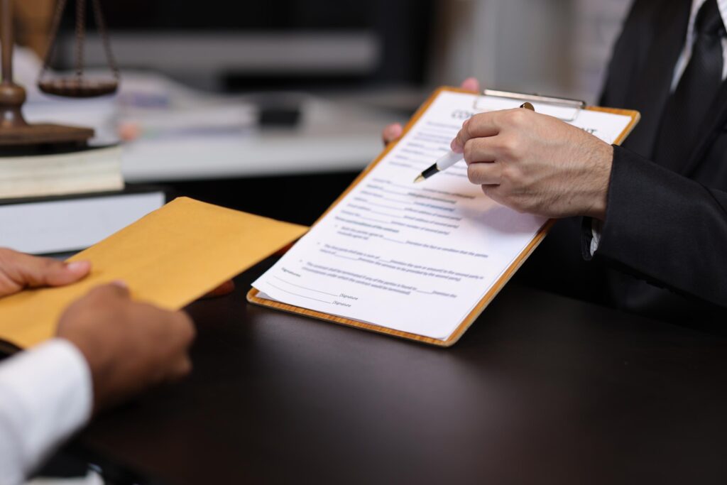 A focused close-up captures a professional man in a sharp black suit and tie as he prepares to sign or review a contract on a clipboard.