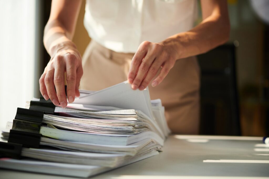 Organised Woman Sorting Documents on Office Desk