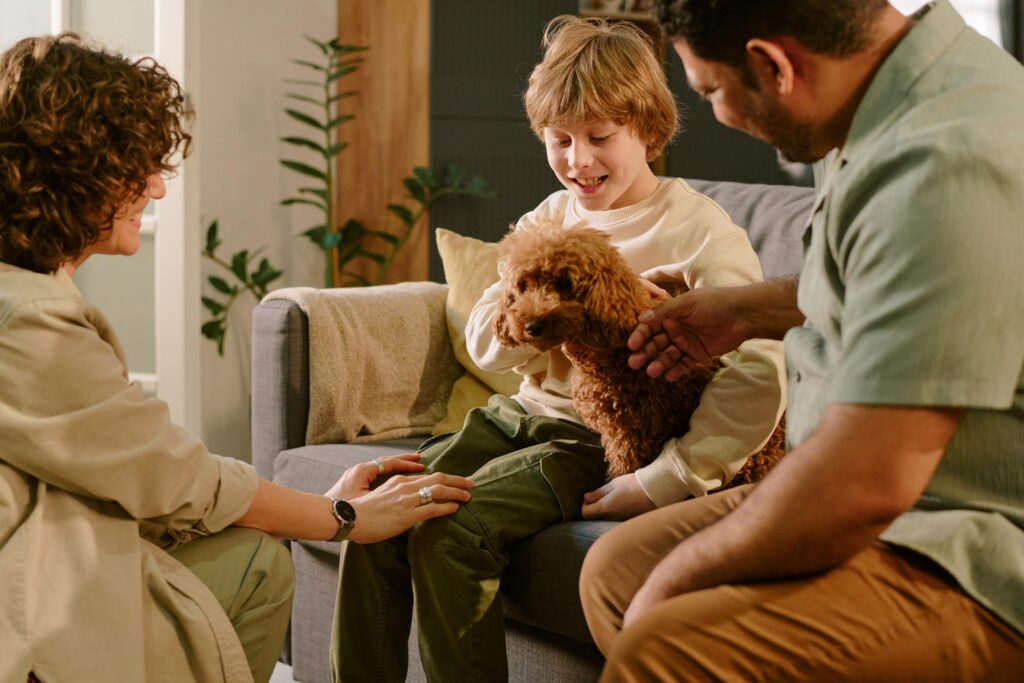 Caucasian Boy Smiling While Meeting First Pet Dog with Parents at Home