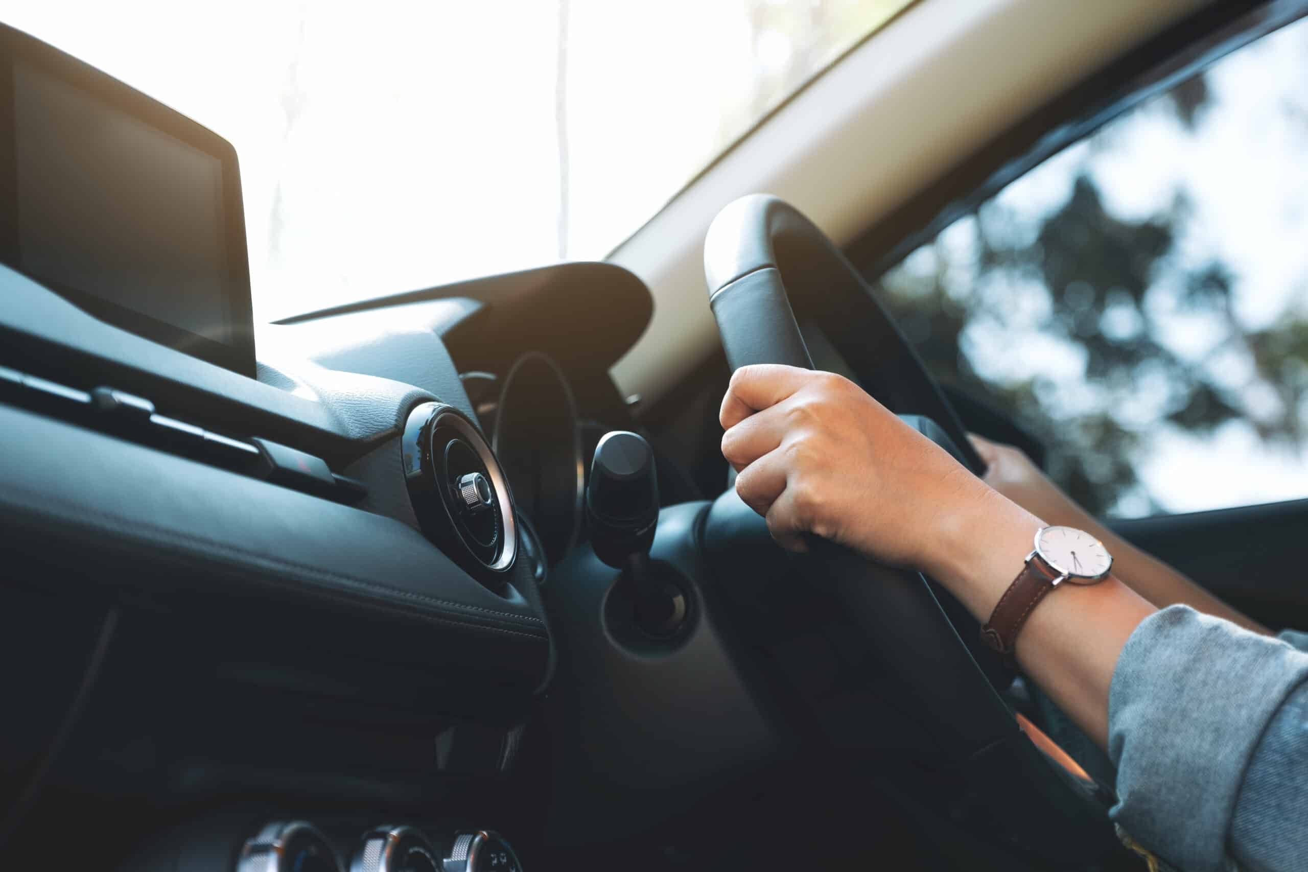 Driving with hands on steering wheel in car