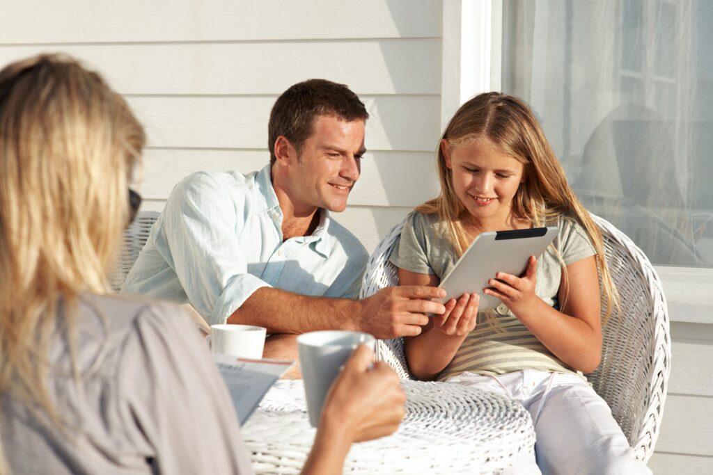 Father and Daughter Using Tablet Outdoors During Golden Hour