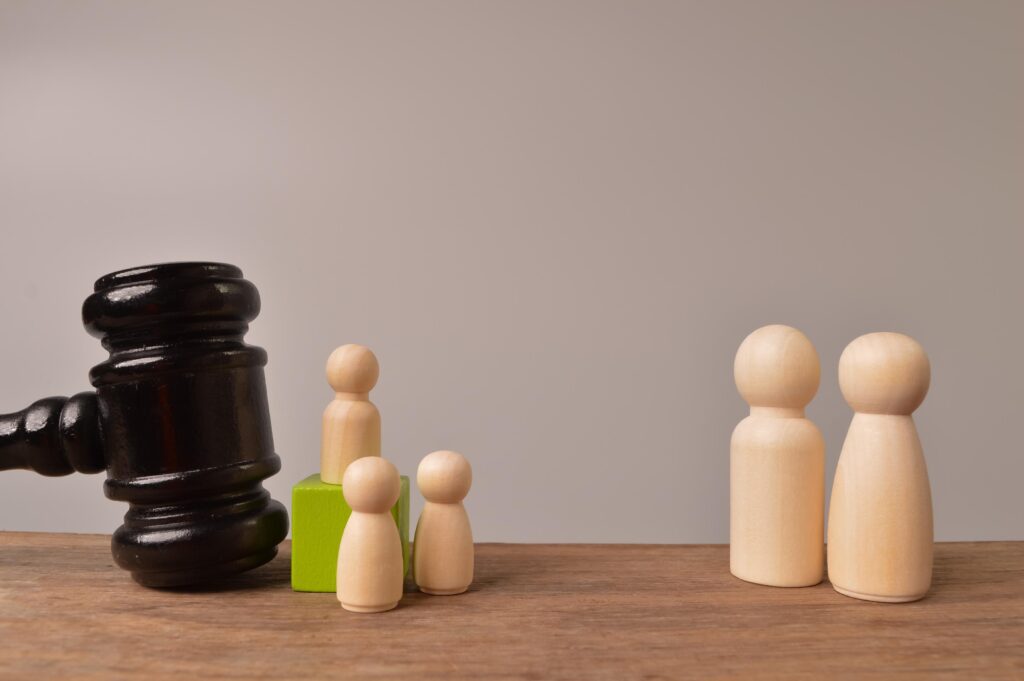 Wooden doll figures and judge gavel. The concept of children protection from the criminal offence.