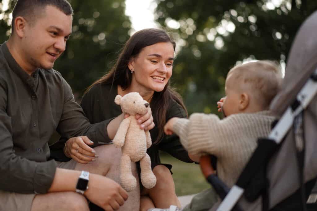 Happy family playing with a plush toy outdoors
