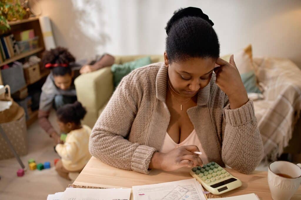 Focused Woman Using Calculator and Reviewing Documents at Home