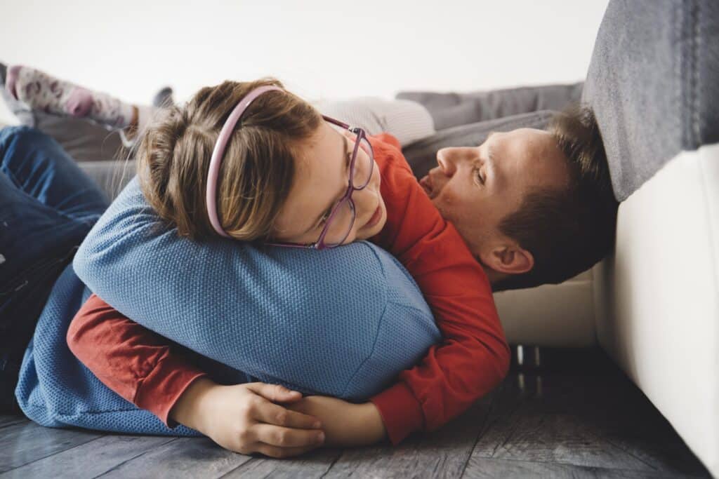 Father and Child embrace at Home on Floor