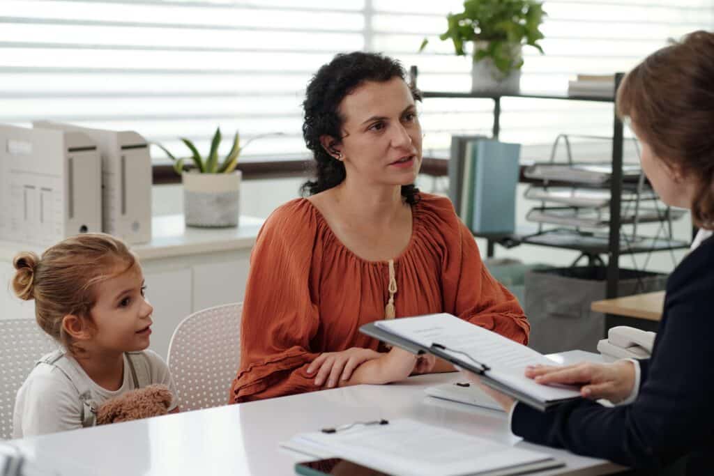 Woman and Child Discuss Documents in Office Setting